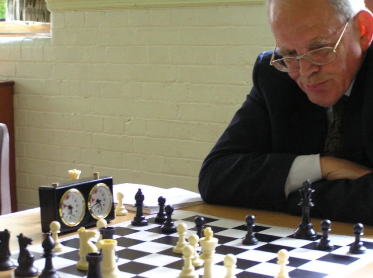 an old man looking at the clock on a chess board