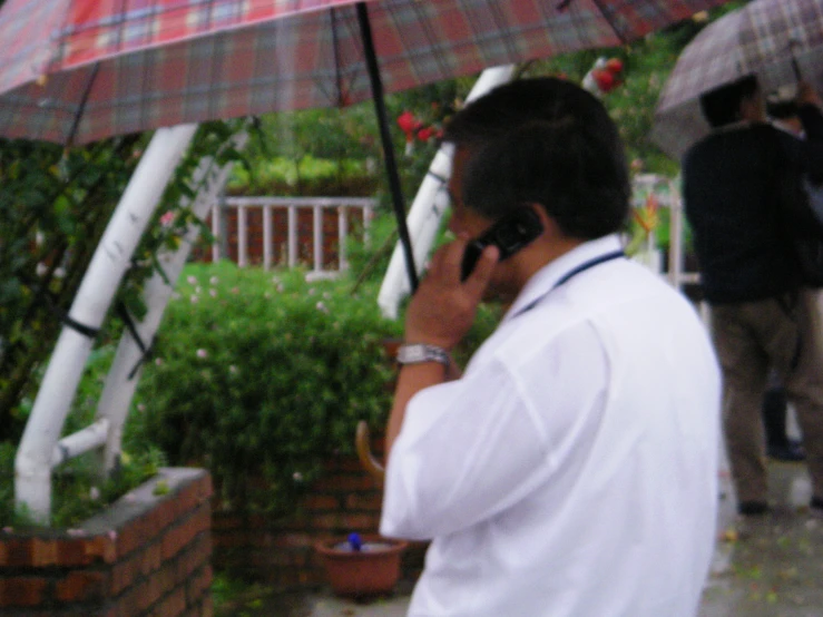 a person talking on a phone and holding an umbrella