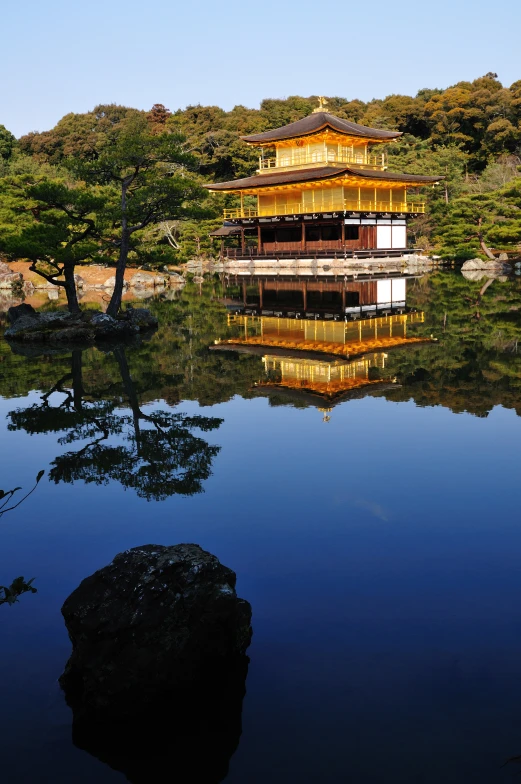 a pagoda and water on a lake surrounded by trees