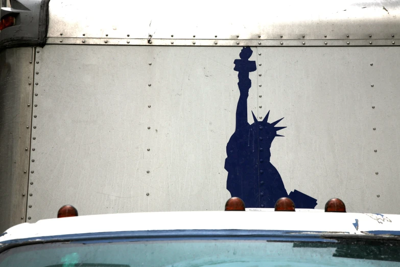 a big truck parked near a statue of liberty painted on the side of the truck