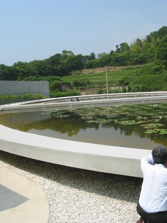 a man sitting on a bench looking at the water