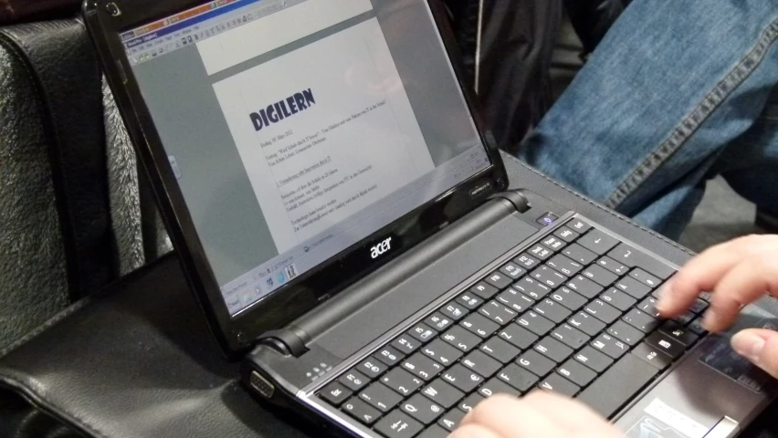 a person working on a laptop with one hand on the keyboard