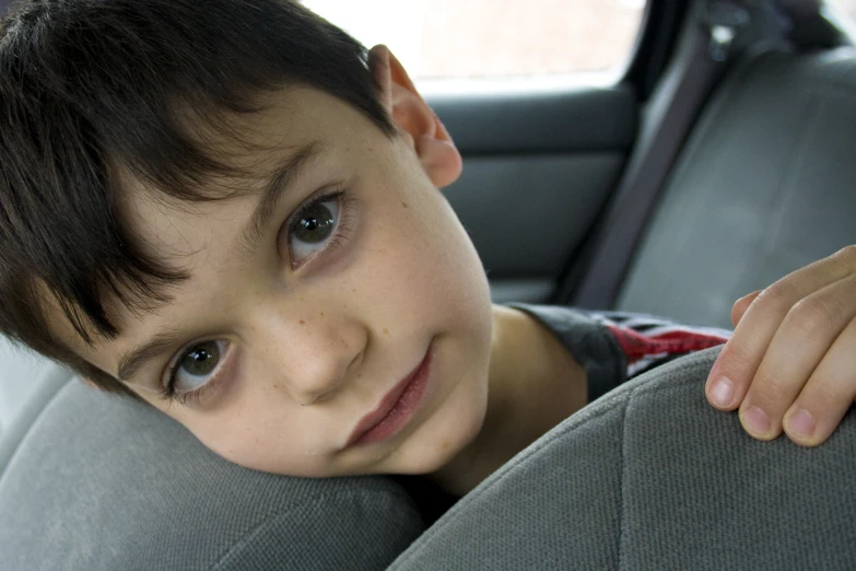 a little boy sitting in a car seat
