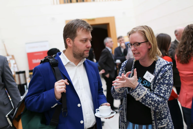 people talking and drinking in a crowded room