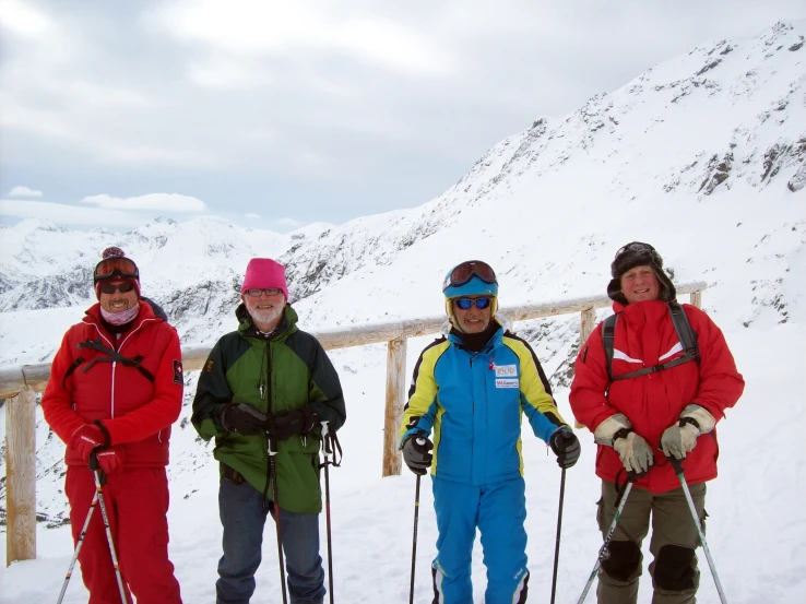 four people are standing in the snow on skis