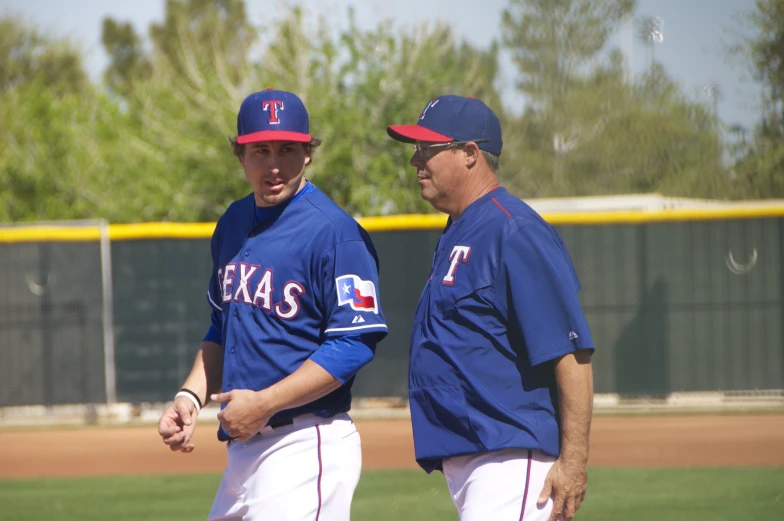 two baseball players standing on the field talking