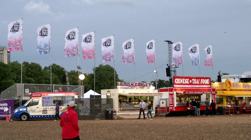 a group of people are lined up at a food stand