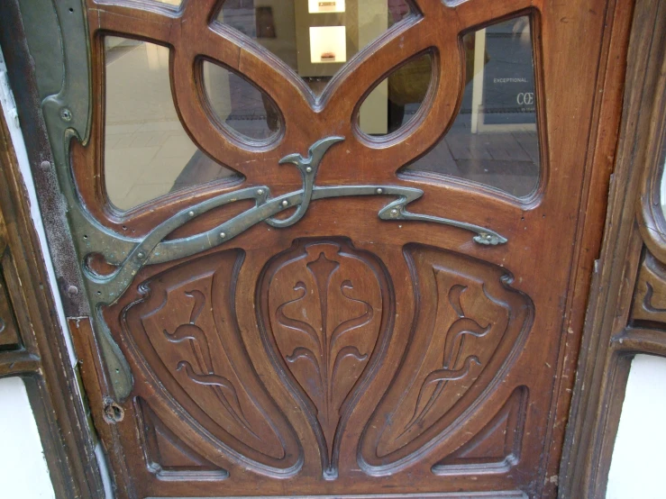 an ornate wooden door with a window to the street