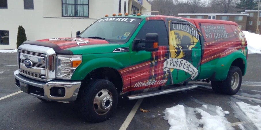 a green and red truck with a lion painted on the side