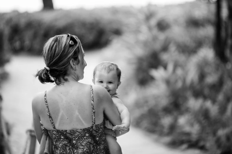 a woman holding a baby up to her back