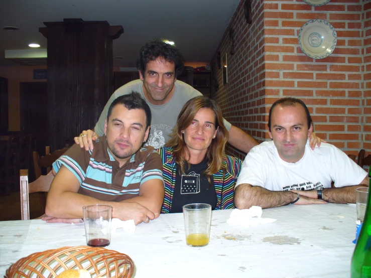 three people posing for a picture while sitting at a table