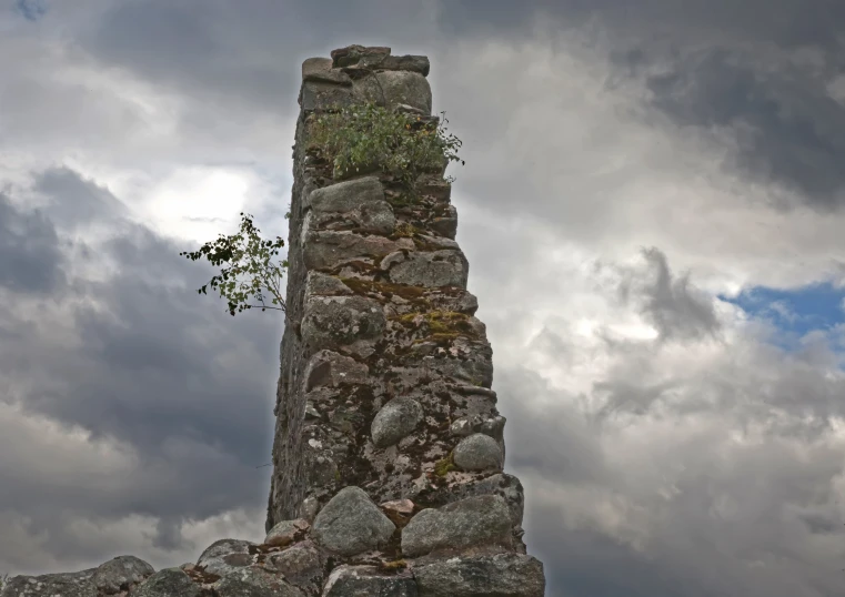 a large tall stone structure with flowers growing out of it