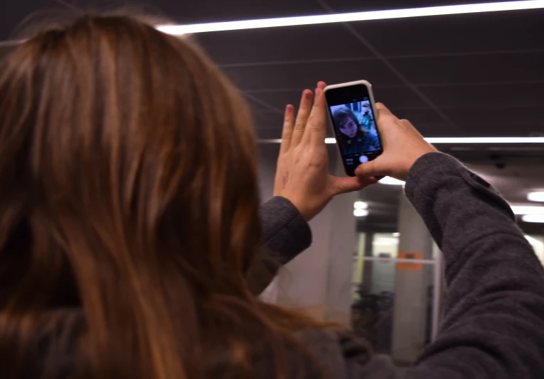 a woman taking a picture with a smart phone