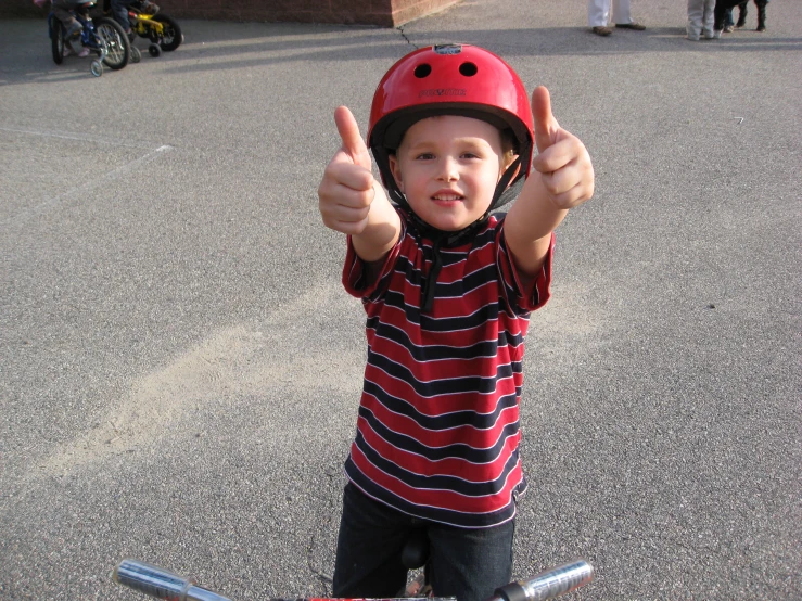 the boy is wearing a red helmet and pointing