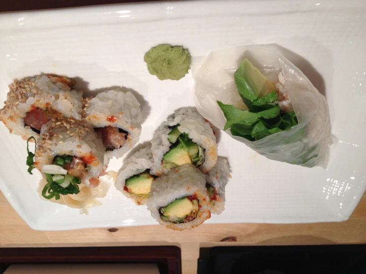 there is a sushi roll and another one has green sauce on it