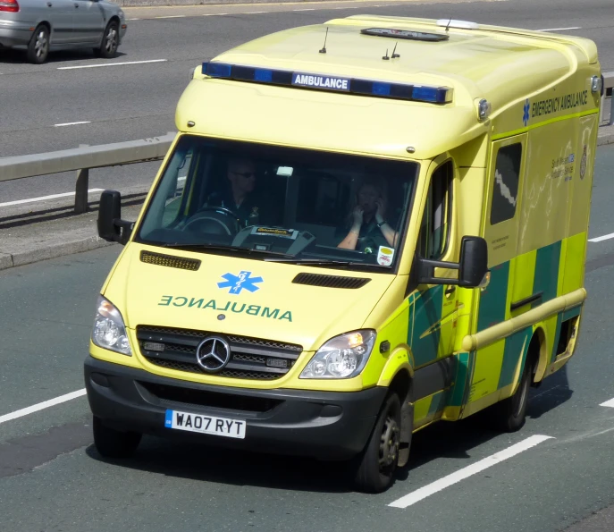a ambulance parked at a traffic light in traffic