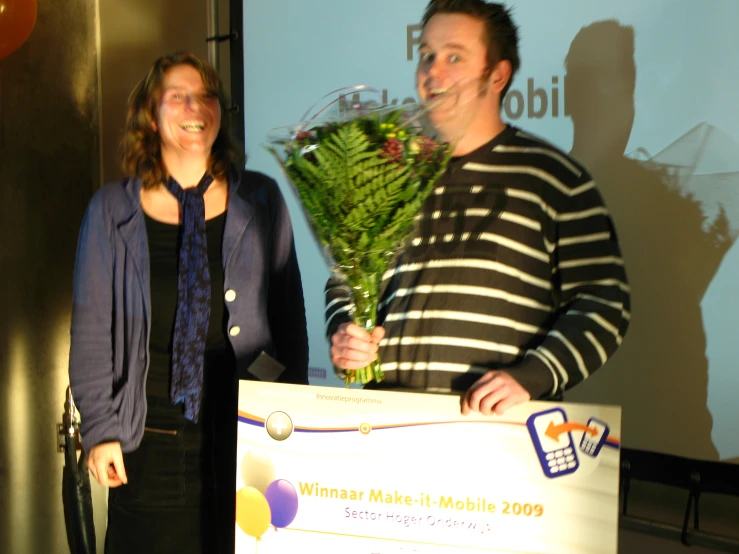 two people hold a giant check, and smile