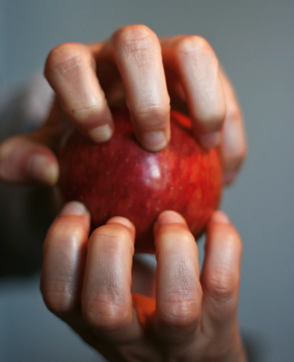 a person holding an apple in one hand