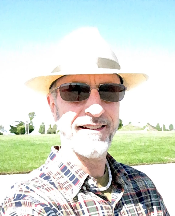 a man wearing a hat and glasses looking at the camera