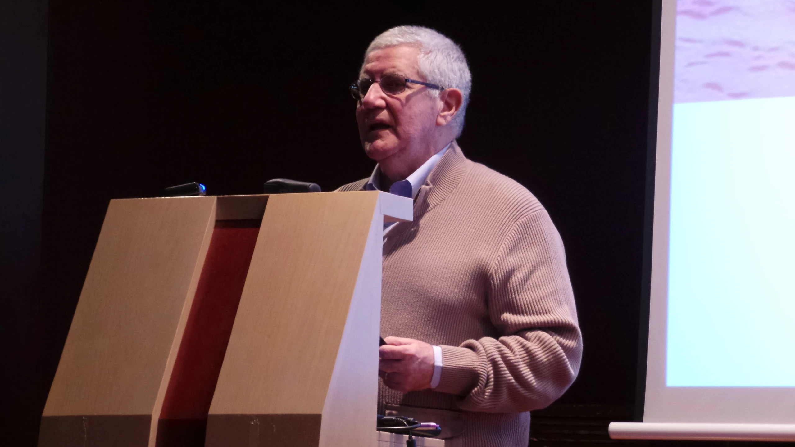 an older man is making his point while giving a speech