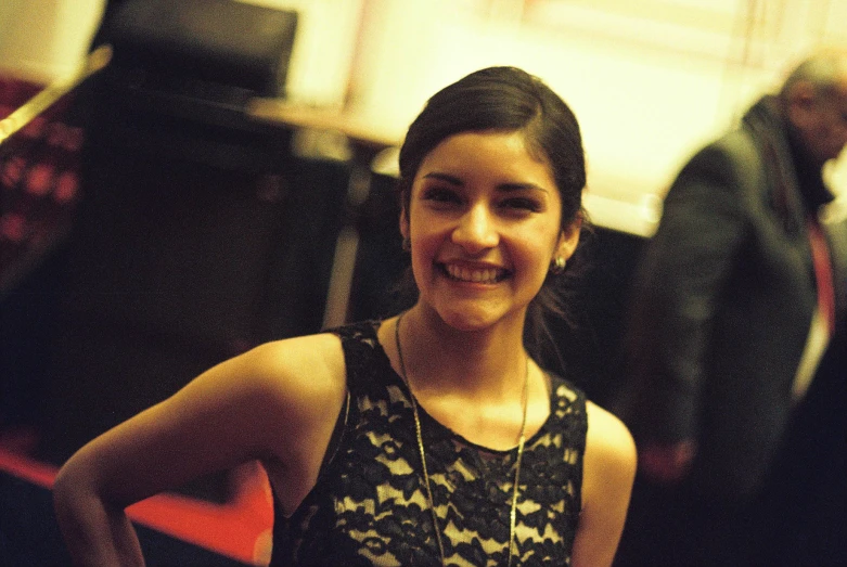 a woman standing in a hallway smiling for the camera