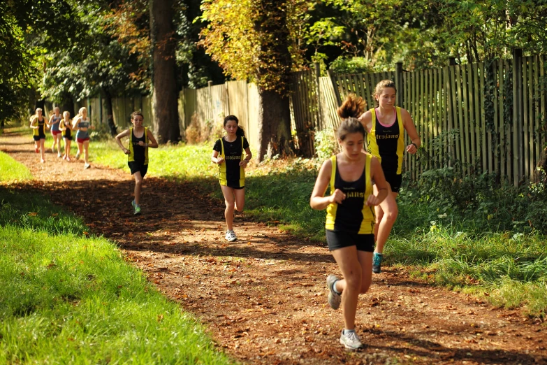 a group of girls run down the path