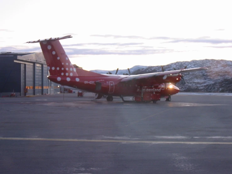 a red and white airplane is sitting on the runway