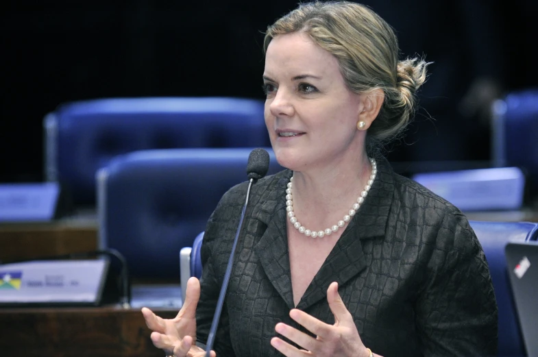 woman standing in front of microphone making a presentation