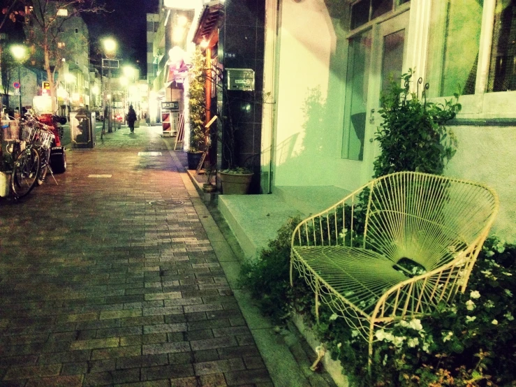 a green bench sitting on the side of a road