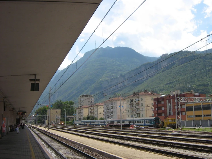 a train track in front of a green mountain