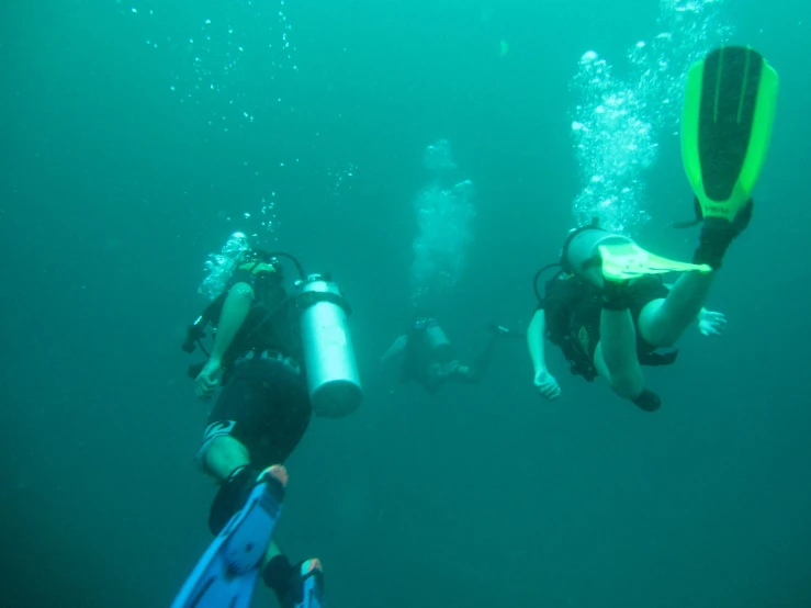 four people in a large tank being used as a life raft for divers