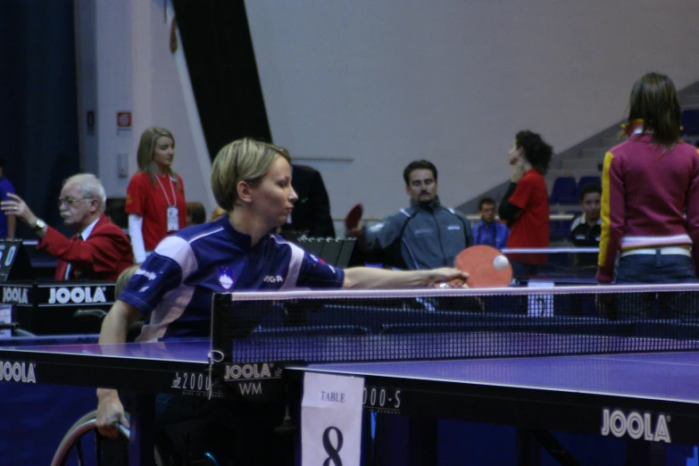 a woman in black shirt holding a ping pong racket