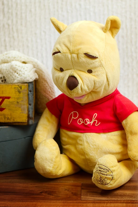 the winnie the pooh bear toy is sitting in front of some toys