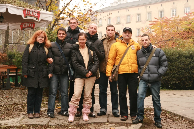 a group of people posing for a po in front of some buildings