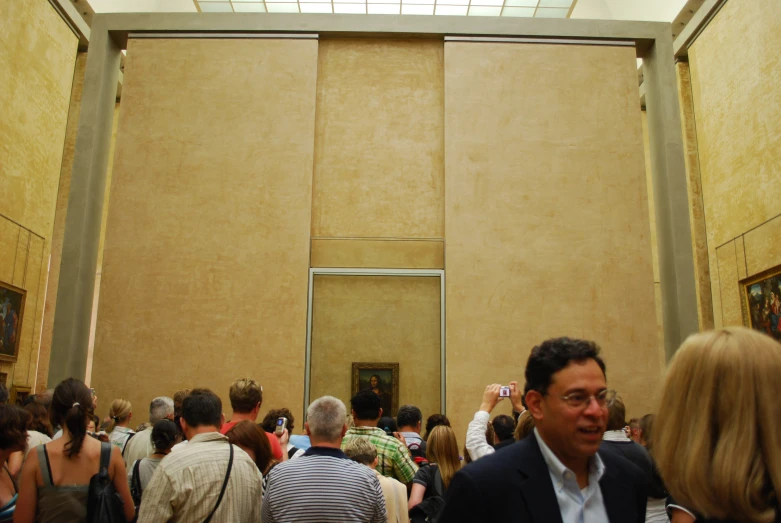 a large group of people walking through an art gallery