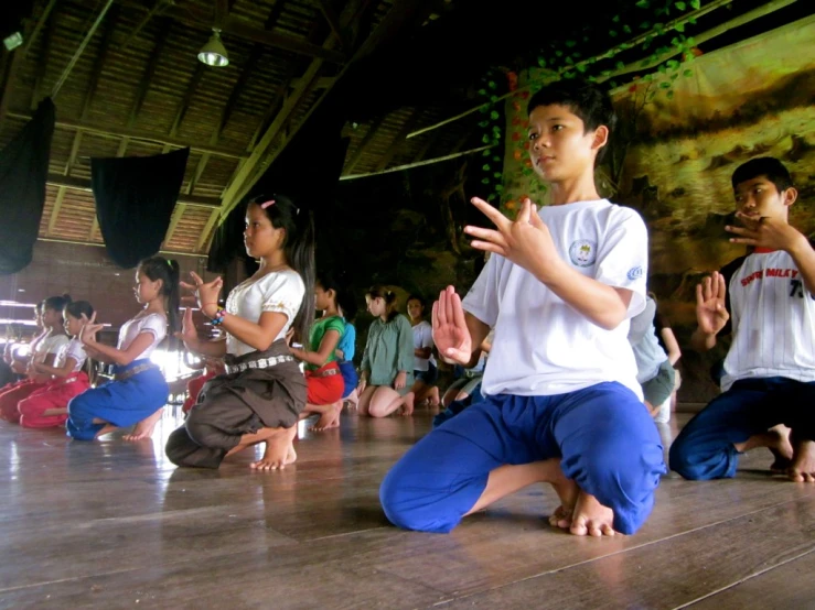 a group of young people sit on a floor while doing yoga