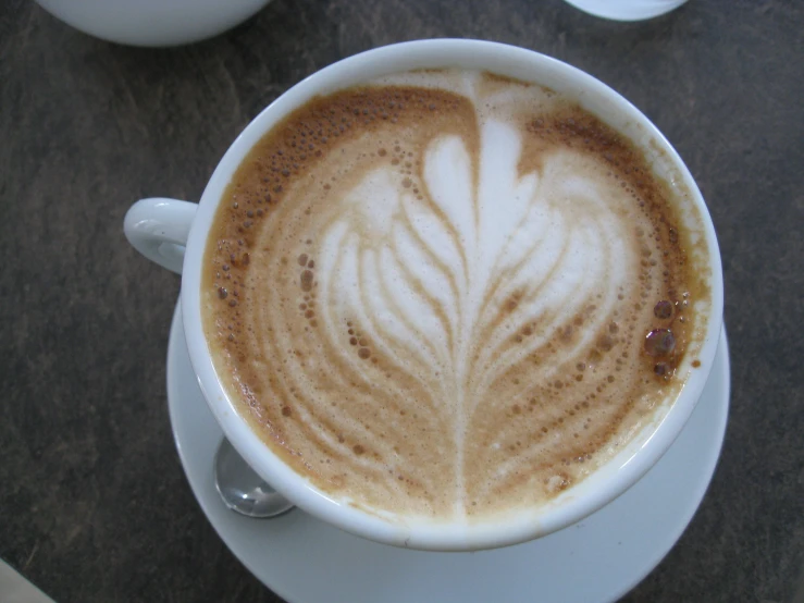 an artisticly painted cappuccino with spoons