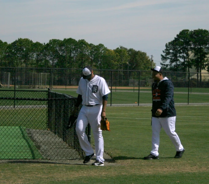 three men in baseball uniforms stand together on a baseball field
