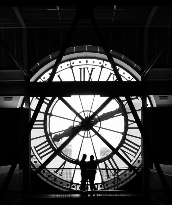 two people are standing inside of a large clock
