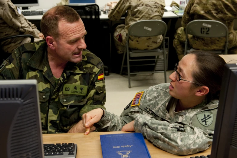 soldier showing a woman soing on a lap top