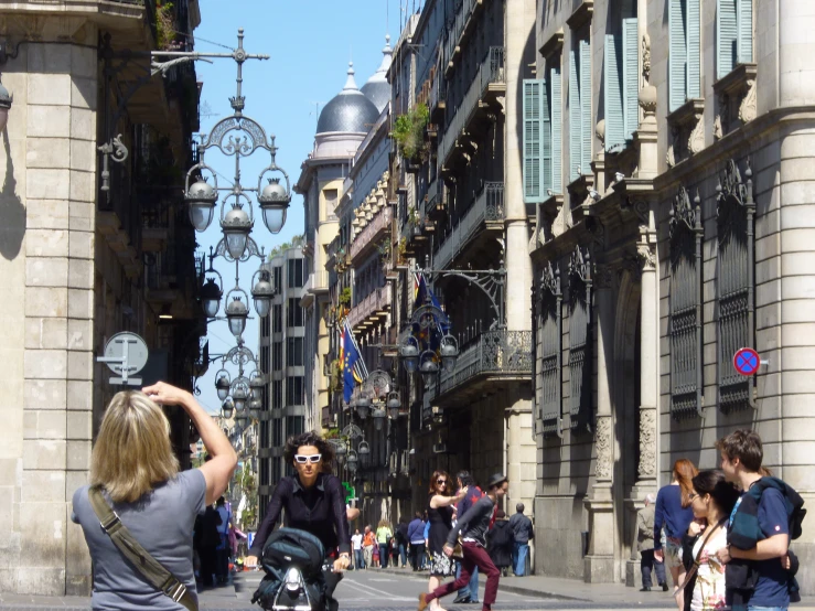 people on a street, a woman taking pictures