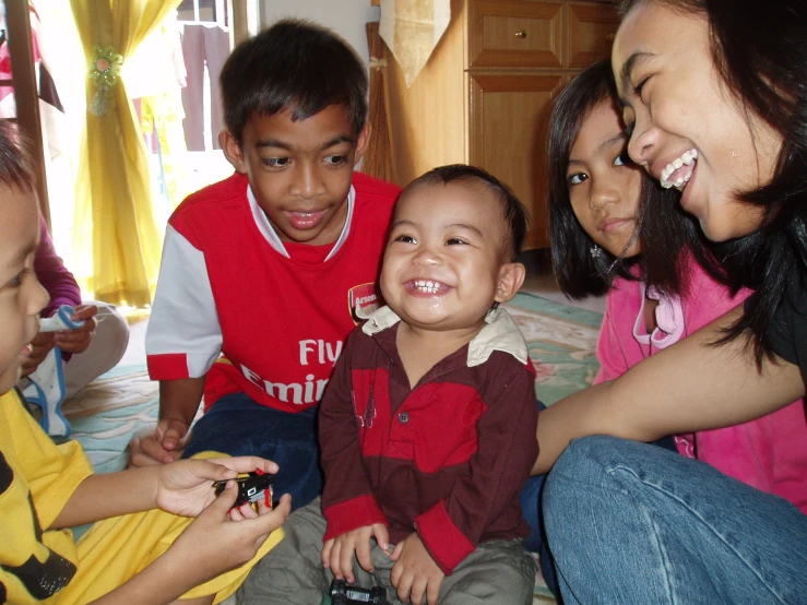 a group of people sitting around a baby smiling