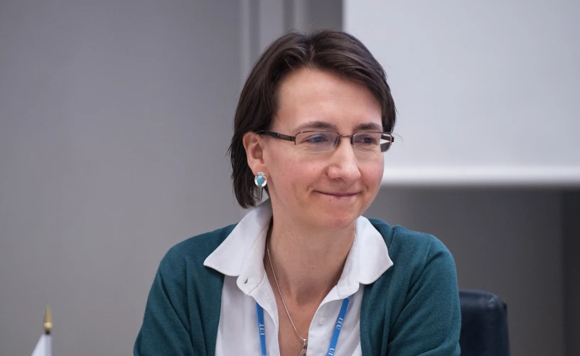 woman wearing glasses at a table talking