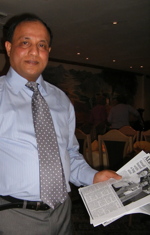 a man holds some newspapers in his hand