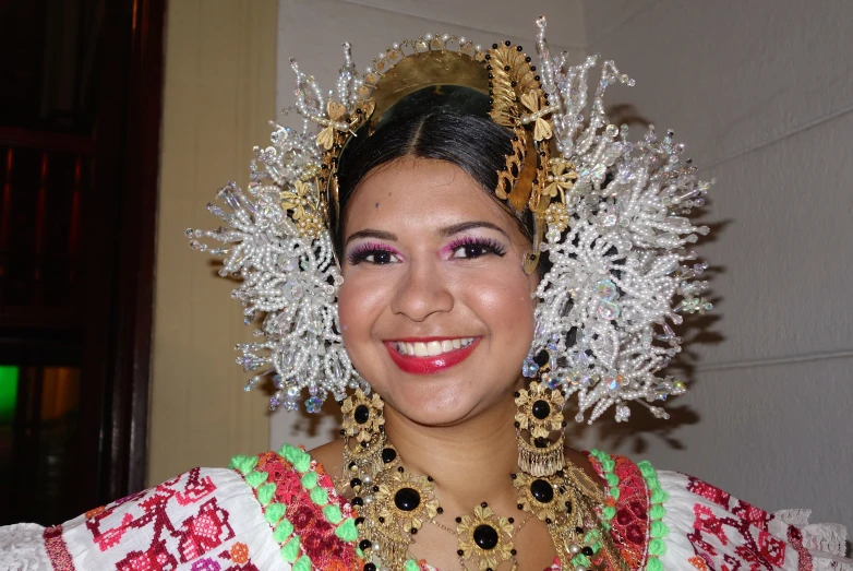 a smiling woman in an elaborate head dress