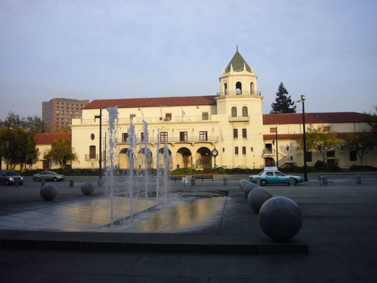 a fountain in front of a building with fountains on each side