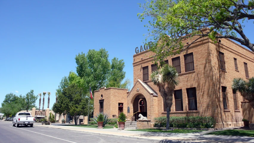 an intersection near trees and buildings on a sunny day