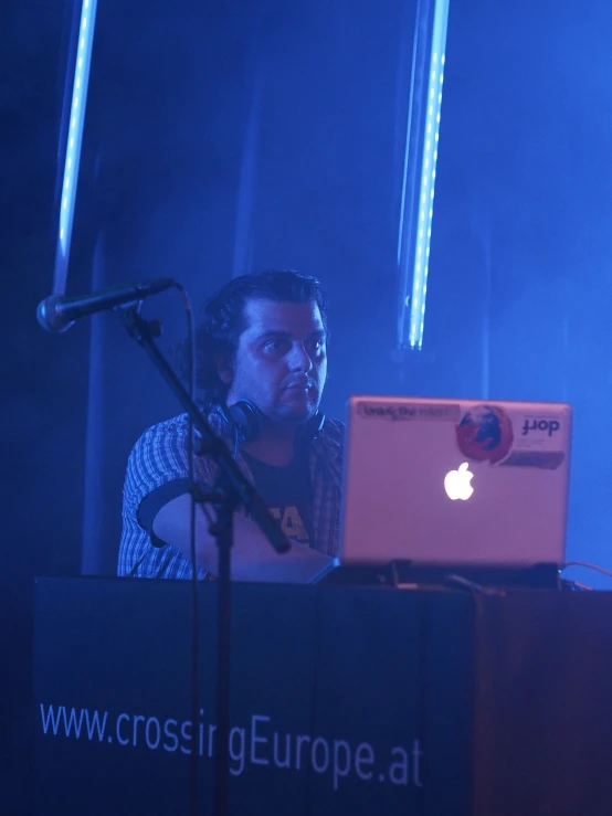 there is a man sitting at the keyboard with an apple laptop