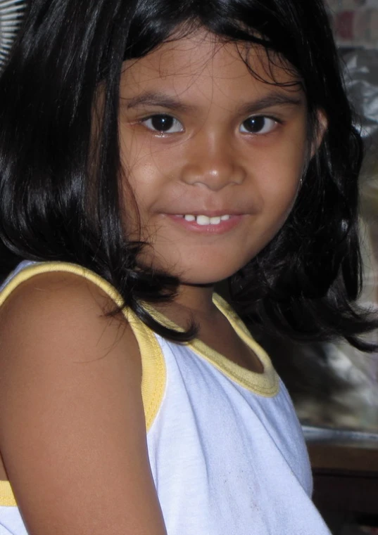 a little girl posing for the camera with a smile