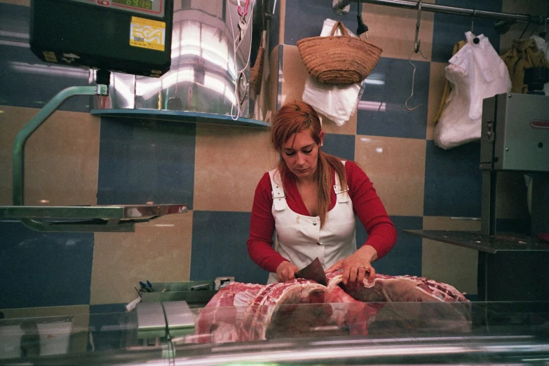 the woman cuts up meat on a table